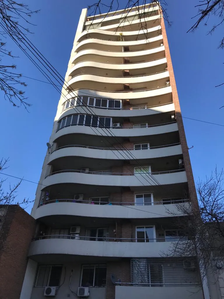 Edificio de departamentos con balcones curvos sobre una calle de Rosario