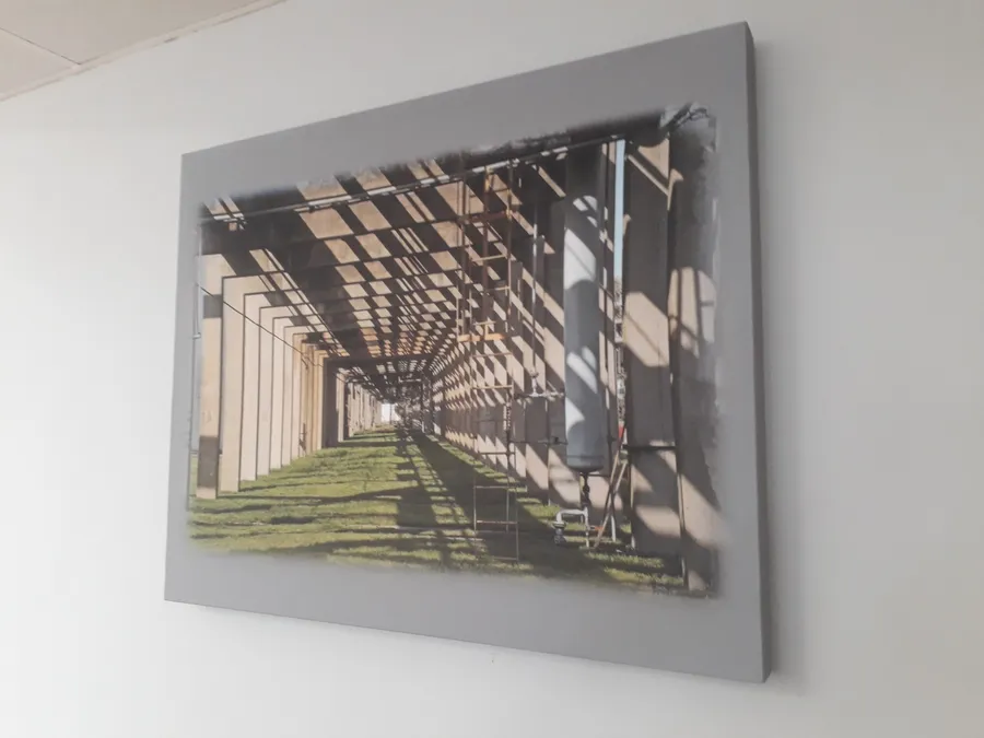 Panel acústico impreso con una fotografía industrial en la pared de una oficina