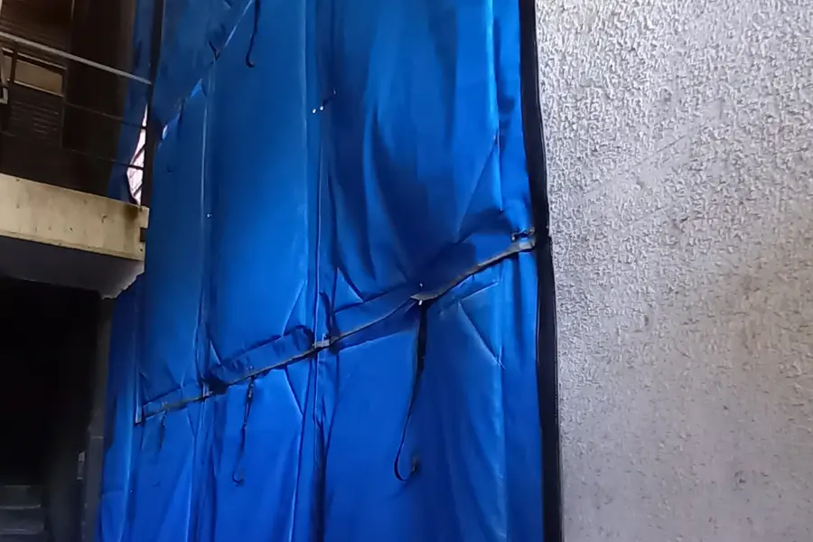 Mantas acústicas cerrando el aire luz de la sala de máquinas de un edificio corporativo, junto al muro del edificio vecino