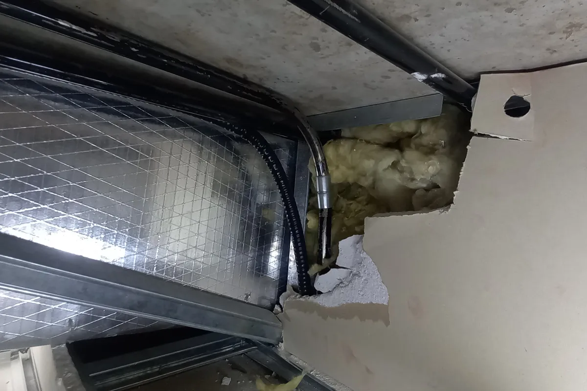 Conducto de climatización que atraviesa el tabique entre dos salas por encima del cielorraso